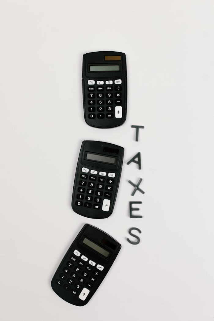 Flat lay of three calculators with TAXES text on a white background.